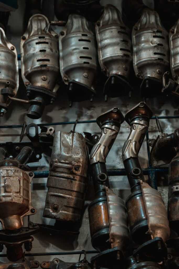 Rows of used catalytic converters in an automotive workshop setting.
